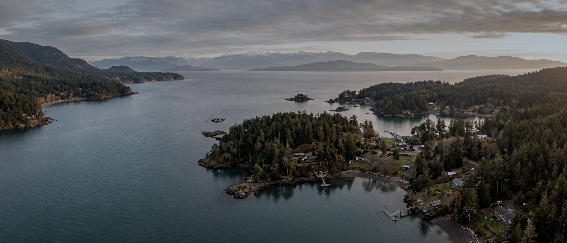 High aerial view along the south coast of Vancouver Island with islands, inlets and distant mountains
