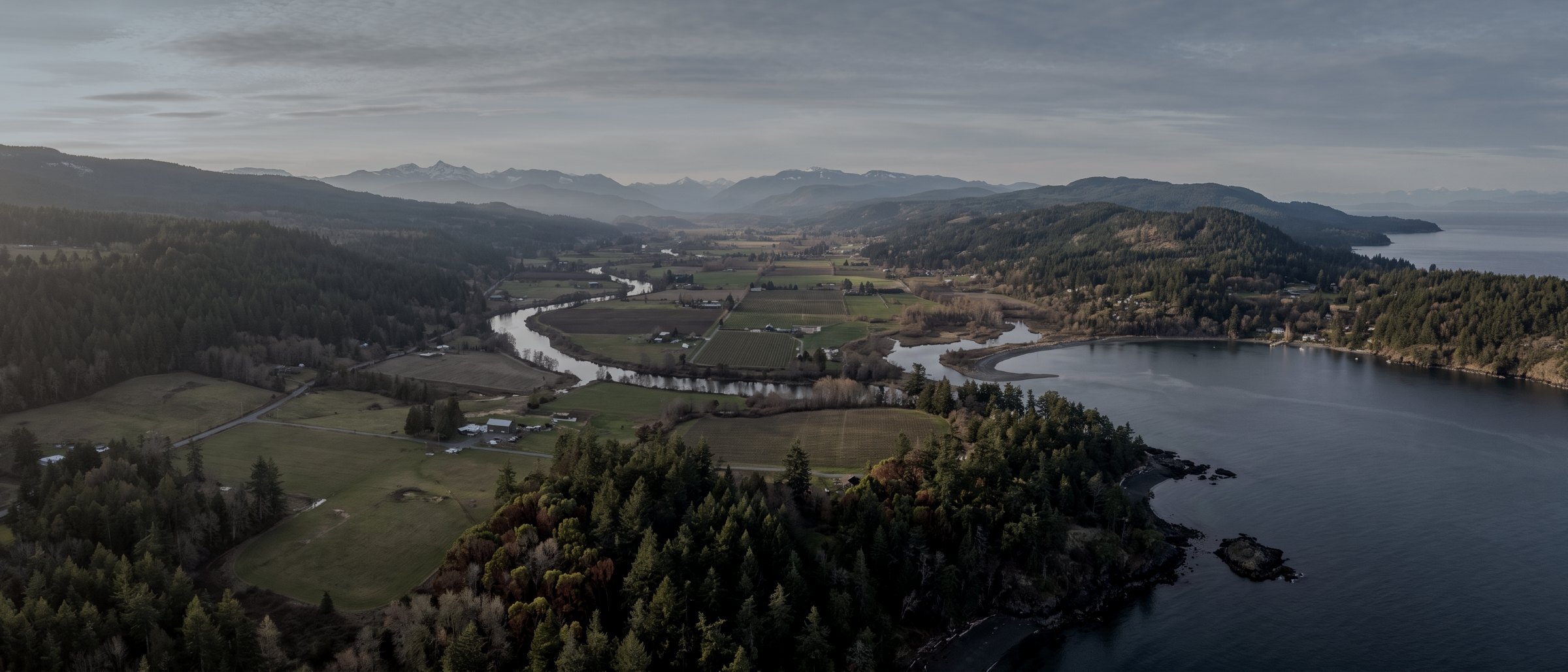 Aerial view over the Cowichan Valley with farmland, the river and Cowichan Bay