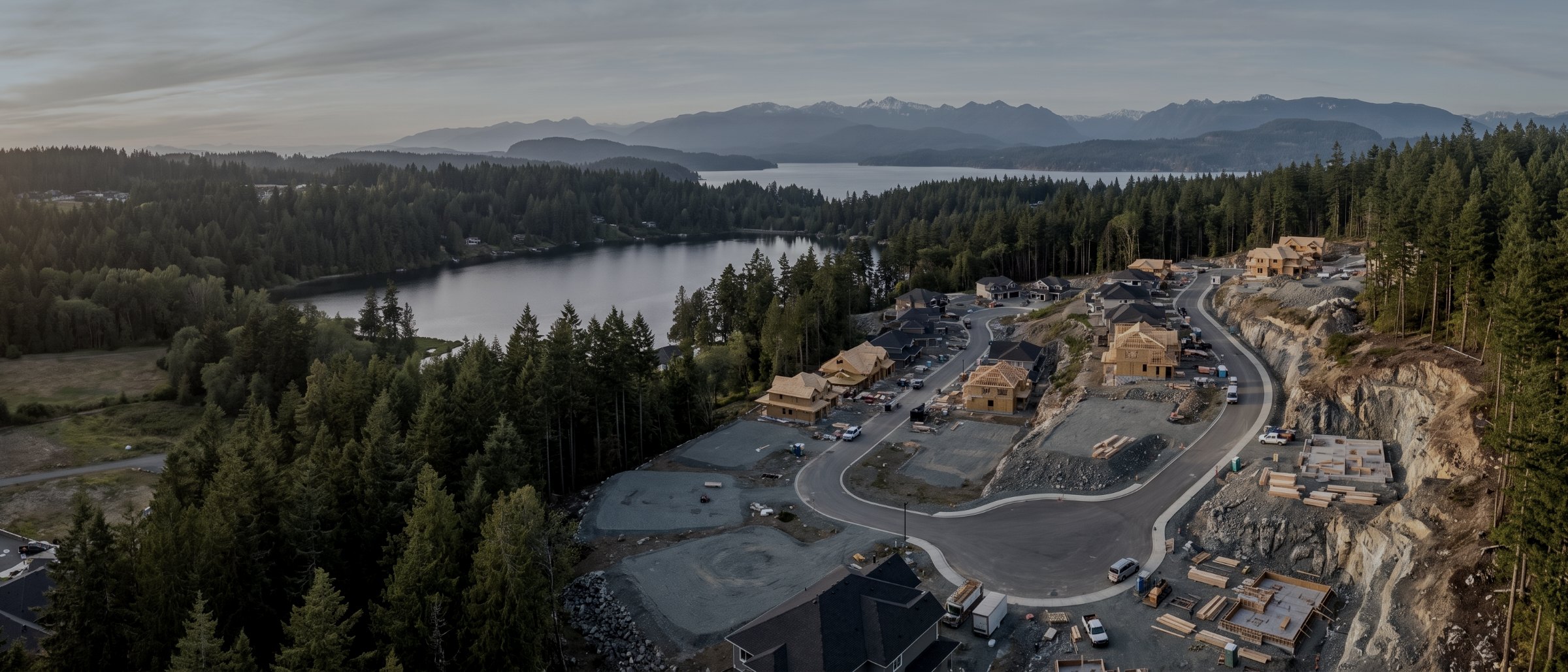 Aerial view over new development in Langford with framed houses, new roads and forest